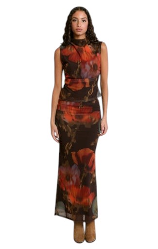 Modèle portant une jupe longue fluide La Maison du Bleuet à motif floral rouge et orange sur fond brun